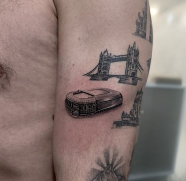 Tatuaje microrealismo en Madrid de Tower Bridge y estadio de fútbol con detalle