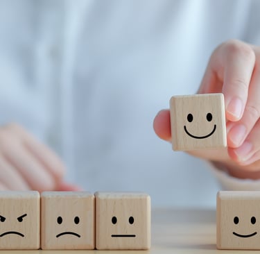 Selecionar manualmente um ícone de rosto feliz em blocos de madeira representando a satisfação