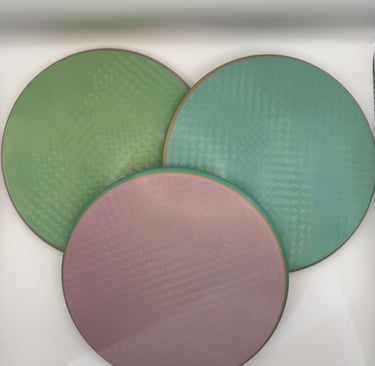 Three circular textured silicone baking mats in green, teal, and pink colors.