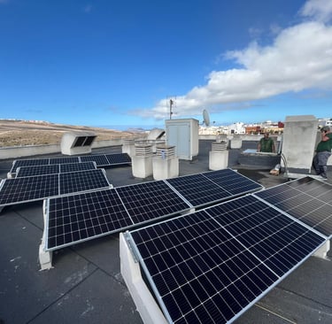 a man standing on a roof top with solar panels
