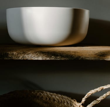 Basin lit by soft side-light in a French Mediterranean bathroom.