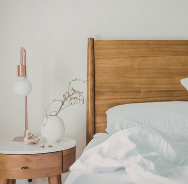 Wood frame and linen bedding in a French Mediterranean bedroom.
