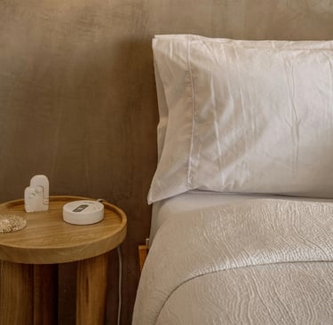 Linen, wood and plaster in a French Mediterranean bedroom.