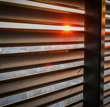 Softened light through a shutter in a French Mediterranean bedroom..
