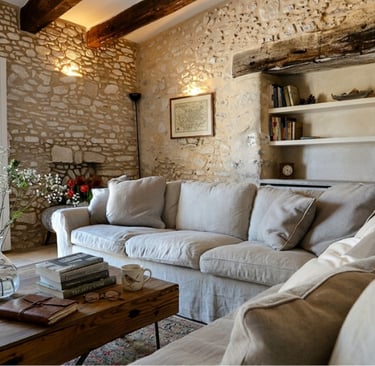 French Mediterranean living room with limewashed walls, low linen sofa, and natural daylight from ta
