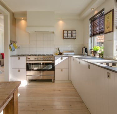 Calm Mediterranean kitchen with a natural stone worktop and simple wood cabinetry in warm morning li