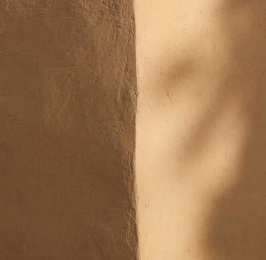 Soft light moving around the corner where two plaster walls meet.