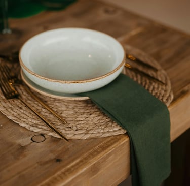 Muted olive and warm wood in a French Mediterranean dining room.