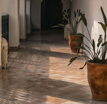 Long golden afternoon shadows stretching across a terracotta floor