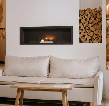 Low linen sofa anchoring a calm French Mediterranean living room, with plaster wall and soft dayligh