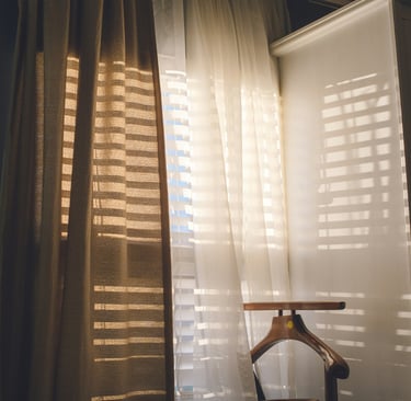 Inside wooden shutters on a new build window, filtering morning light.