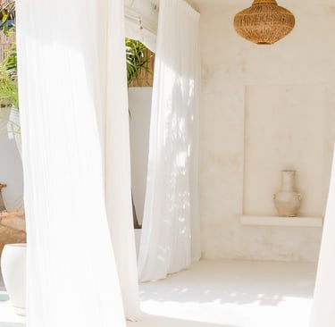 An open terrace door at the threshold between a Mediterranean house and its garden.
