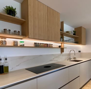 Simple Mediterranean kitchen cabinetry in a warm matte finish with one open shelf.