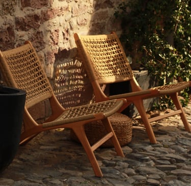 Weathered teak and matte metal furniture on a French Mediterranean terrace.