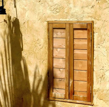 Weathered oak against a lime-washed wall in a French Mediterranean garden.
