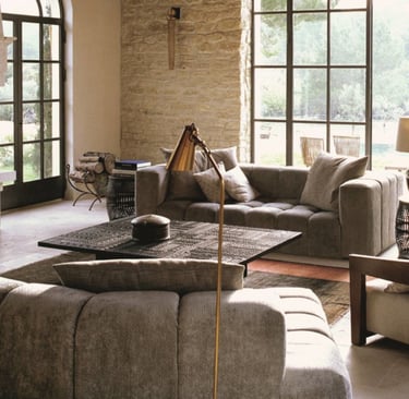 wall, sofa, floor in the same warm neutral family, light moving across