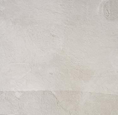 Aged lime-washed wall with traces of ochre and sand pigment.