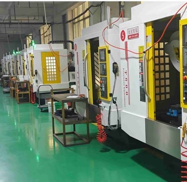 Industrial CNC milling machines lined up in a modern precision manufacturing facility.