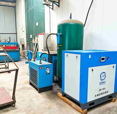 Industrial blue and white JM-30A permanent magnet variable frequency air compressor and green storage tank.