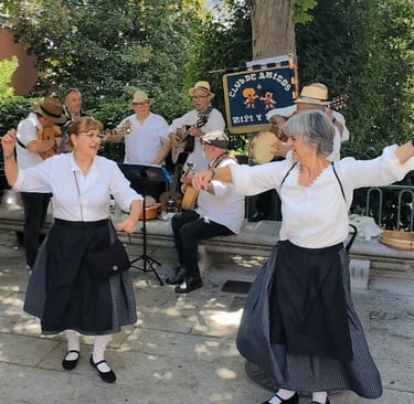 Two women dance a jota while an Escofolk band plays music