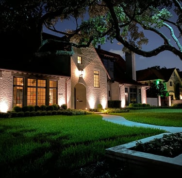 landscape lighting on a nice house facade and lights on trees and steps