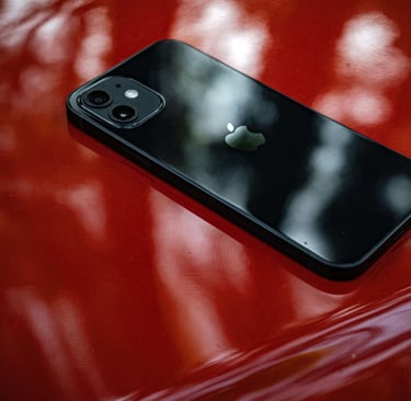 iPhone Km0 negro sobre una superficie roja brillante, resaltando su diseño premium y alta calidad.