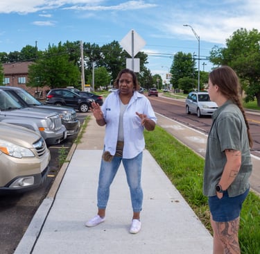 Sophia talking to two young people while standing on a sidewalk