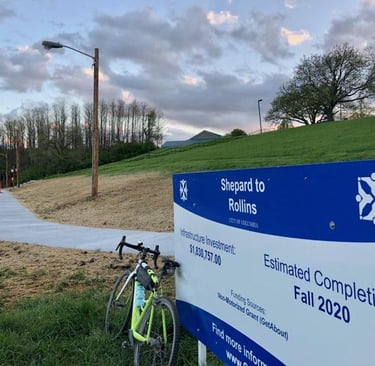 Paved trail with a sign reading "Shepard to Rollins, Estimated Completion: Fall 2020"