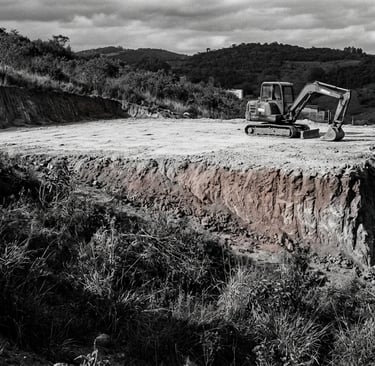 Terreno em desnível com terraplanagem executada parcialmente em apenas um dos níveis da edificação.