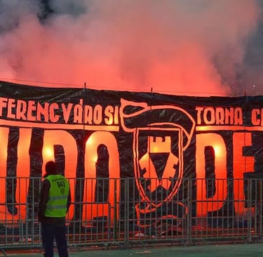 Ferencvárosi TC-Fans im Stadion der Groupama Aréna, jubelnd mit Vereinsfarben und Fahnen, während sie ihre Mannschaft lautsta