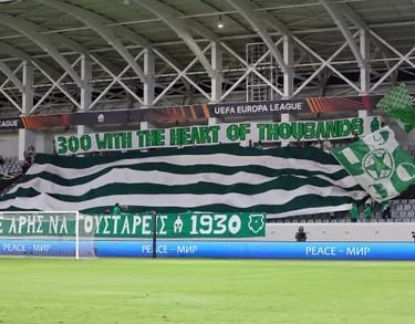 Ultras von Aris Limassol unterstützen ihr Team im Stadion mit Fahnen, Gesängen und Fan-Choreografie.