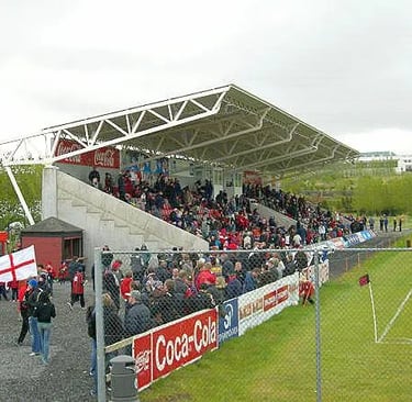 Luftaufnahme des Víkingsvöllur-Stadions in Reykjavík mit Spielfeld, Tribünen und umliegender Landschaft