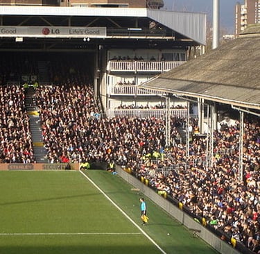 Innenansicht des Craven Cottage in London, Heimstadion des Fulham FC, mit Tribünen, Spielfeld und Blick auf die historische J
