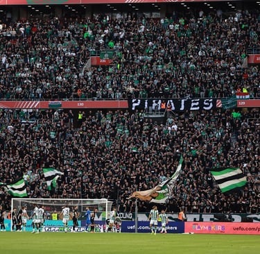 Ferencvárosi TC-Fans im Stadion der Groupama Aréna, jubelnd mit Vereinsfarben und Fahnen, während sie ihre Mannschaft lautsta
