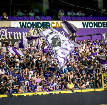 Fans des RSC Anderlecht in violett-weißen Farben beim Anfeuern im Stadion