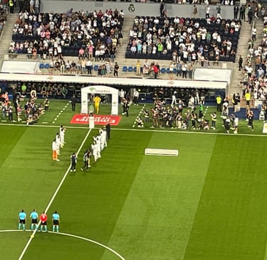 Innenansicht des Estadio Santiago Bernabéu während eines Spiels, mit voll besetzten Tribünen und Fans.