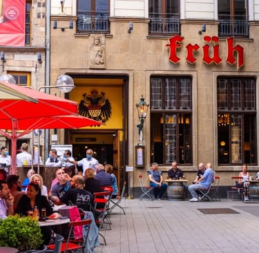 Blick über die Kölner Skyline mit dem Dom im Zentrum, Rhein und urbanen Gebäuden, aufgenommen bei Tageslicht.