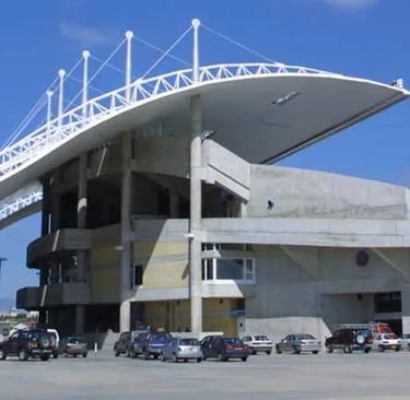 Frontansicht des modernen Eingangsbereichs des GSP Stadium in Nikosia mit klarer, zeitgemäßer Architektur.