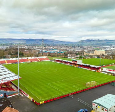 Showgrounds Stadiums in Sligo mit rot-weißen Tribünen, grünem Spielfeld und Heimstadion der Sligo Rovers