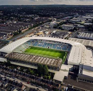 Luftaufnahme des Windsor Park in Belfast mit Blick auf das Spielfeld, die Tribünen und die umliegenden Wohngebiete.