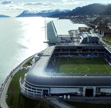 Luftaufnahme des Aker Stadions von Molde FK direkt am norwegischen Fjord mit Bergen und Küstenlandschaft im Hintergrund