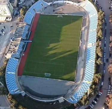 Selman-Stërmasi-Stadion in Tirana aus der Vogelperspektive, Blick auf Spielfeld, Tribünen und umliegende Stadtviertel