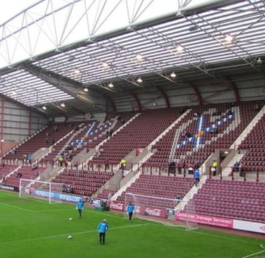 Innenansicht des Tynecastle Park in Edinburgh, Heimstadion des Heart of Midlothian FC, mit Blick auf Spielfeld und Tribünen.