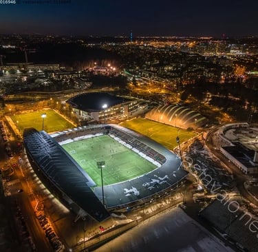 Luftaufnahme der Bolt Arena in Helsinki, einem modernen Fußballstadion mit umlaufenden Tribünen, umgeben von Wohnhäusern und