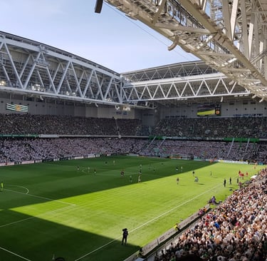 Innenansicht des Tele2 Arena Stadions in Stockholm während eines Spiels von Hammarby IF, mit vollen Tribünen und grün-weißer 