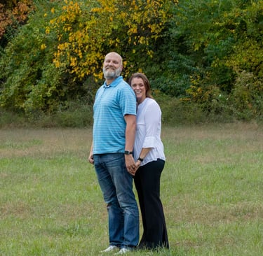 RC & Dustie Mercer photo standing outside in park setting with trees in the background