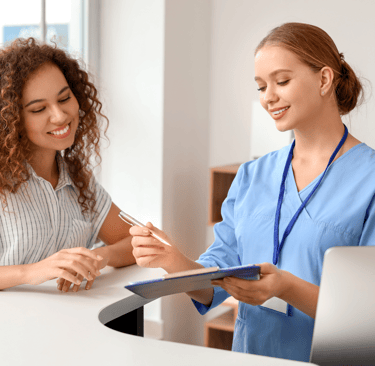 Dental practice front desk with a healthcare administrator and a patient.