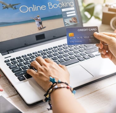 a person holding a credit card in front of a laprop