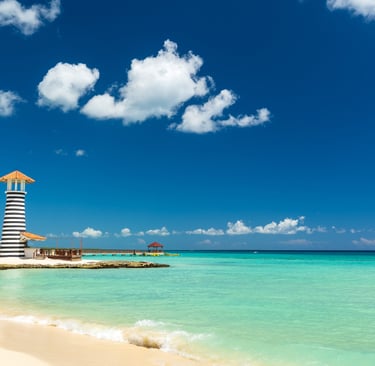 Scenic beach with turquoise water and striped lighthouse in Bayahibe, Dominican Republic