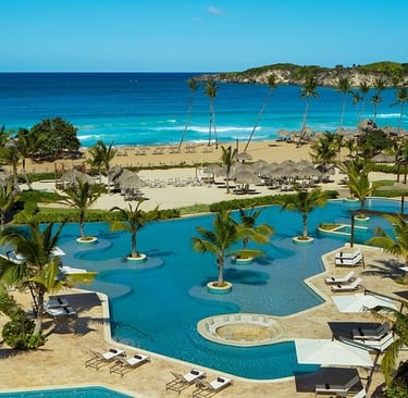 Aerial view of Playa Macao with palm trees, golden sand, and turquoise Atlantic water in Punta Cana